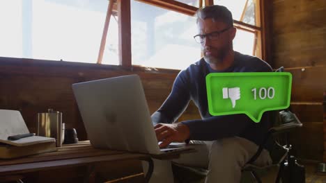 animation of social media icon with growing number over caucasian man using laptop