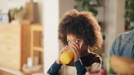 niño bebiendo jugo de naranja