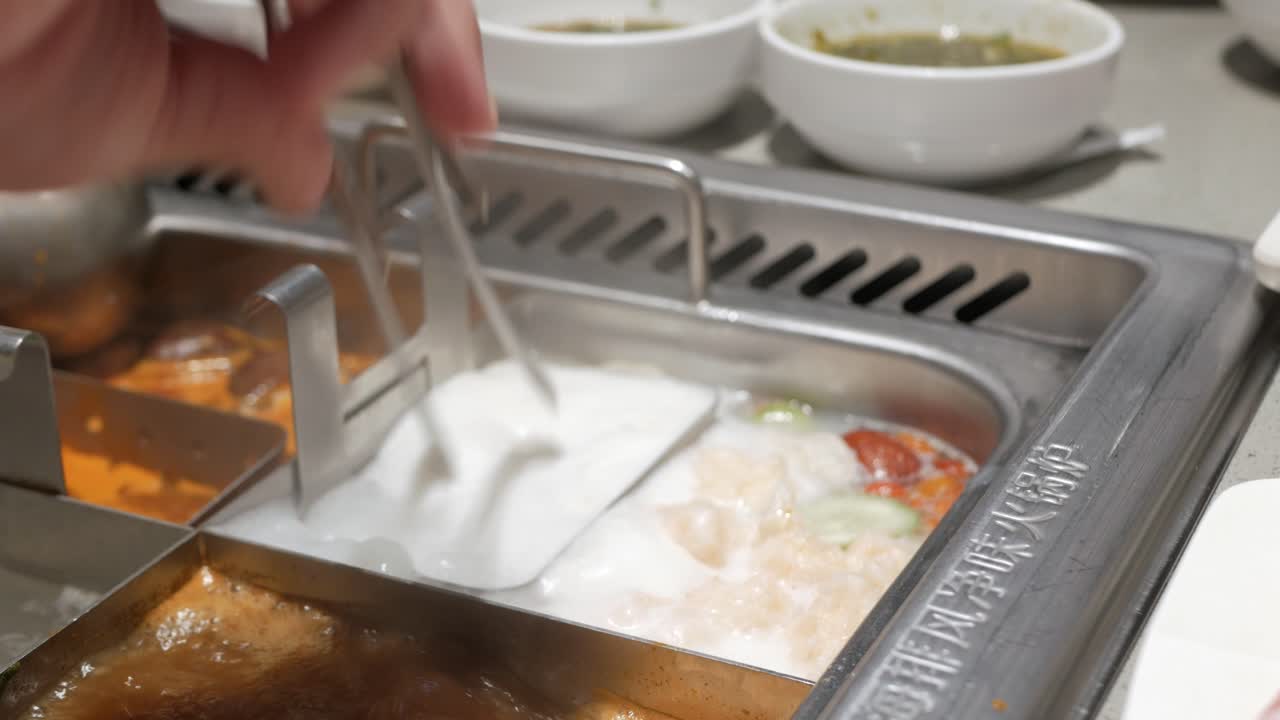 쓰촨 스타일의 중국식 전골에 얇게 썬 돼지고기를 넣는다