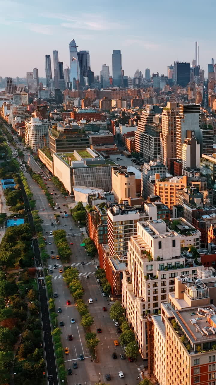 Densely built panorama of New York at sunset. Lively highway on the waterfront near the river. Top view. Vertical video