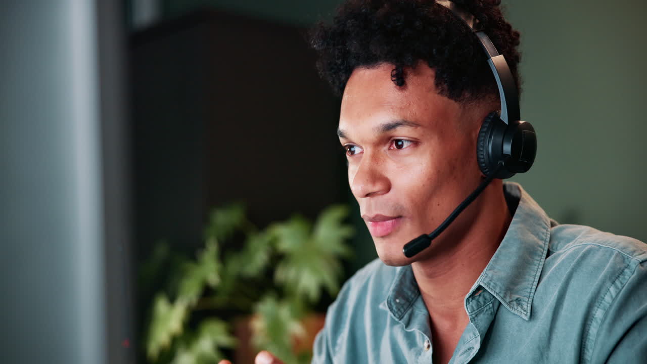 Business Person Wearing Headset and Working on Computer