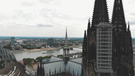 4k-Aerial-footage-pan-out-of-the-Cologne-Cathedral-during-it's-renovation-construction-revealing-the-landscape-of-Cologne,-Germany