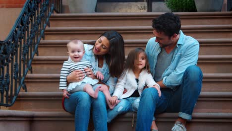 young family with two kids sitting on front stoop, brooklyn