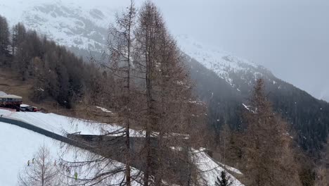 descending slope in a gondola as snow falls passing over children learning to ski