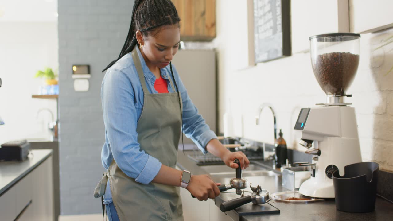 Un barista che prende un portafiltro, macina, pesa, pressa e carica il caffè nella macchina per l'espresso