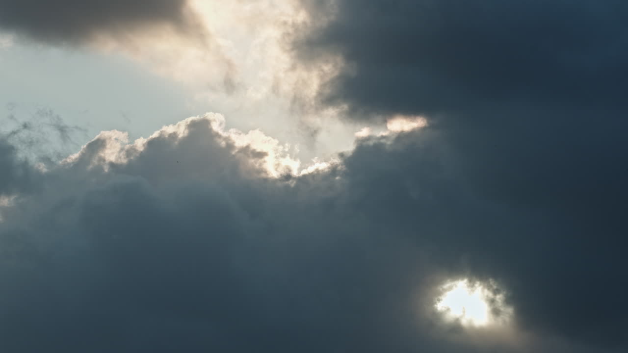 Dramatic clouds shift in a moody sky, showcasing nature's power