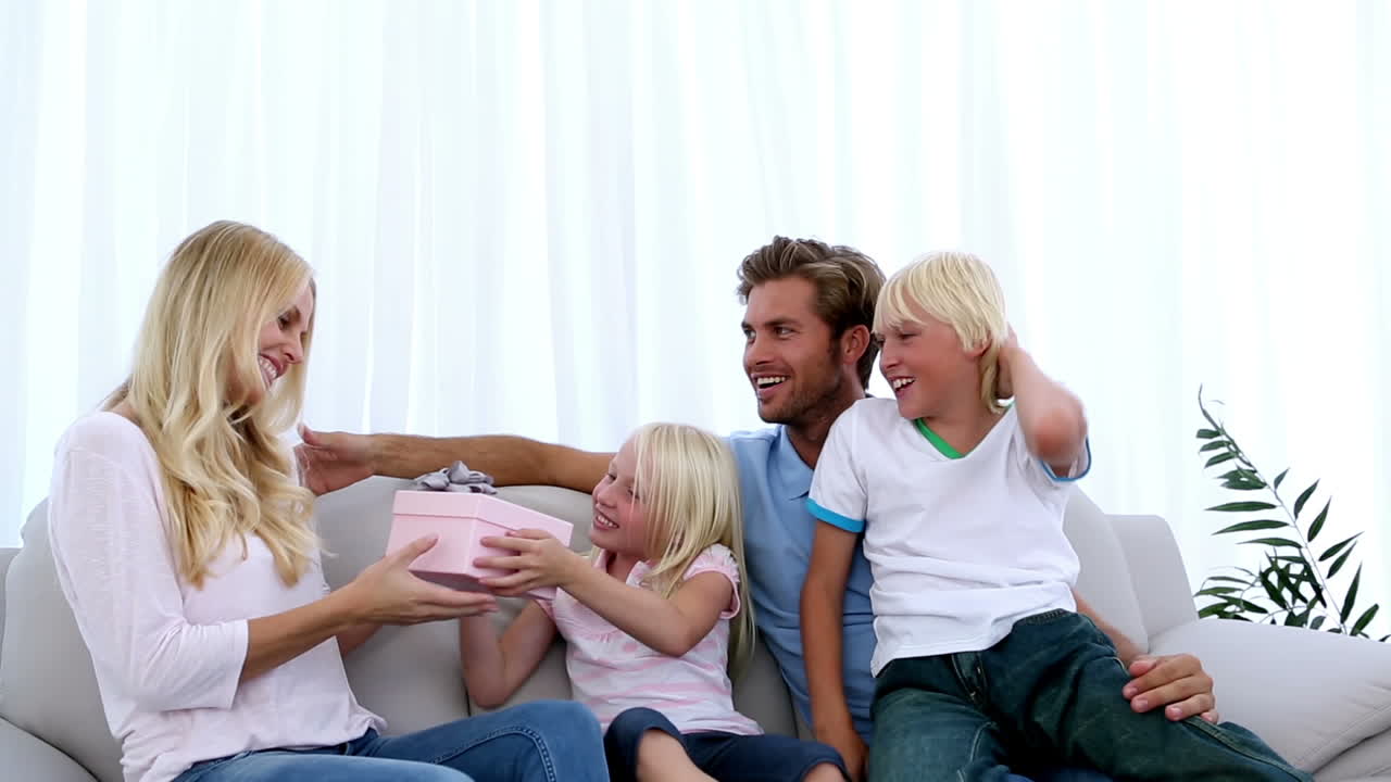 가족 들 이 어머니 에게 분홍색 선물 을 주는 것