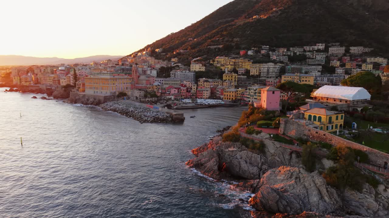 Sunset over Genoa, Italy, aerial view showing the coastline and colorful buildings