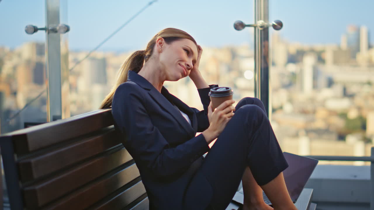 Smiling woman sipping coffee on office balcony. Happy manager resting alone