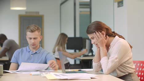 mujer joven leyendo malas noticias en una computadora portátil en un coworking