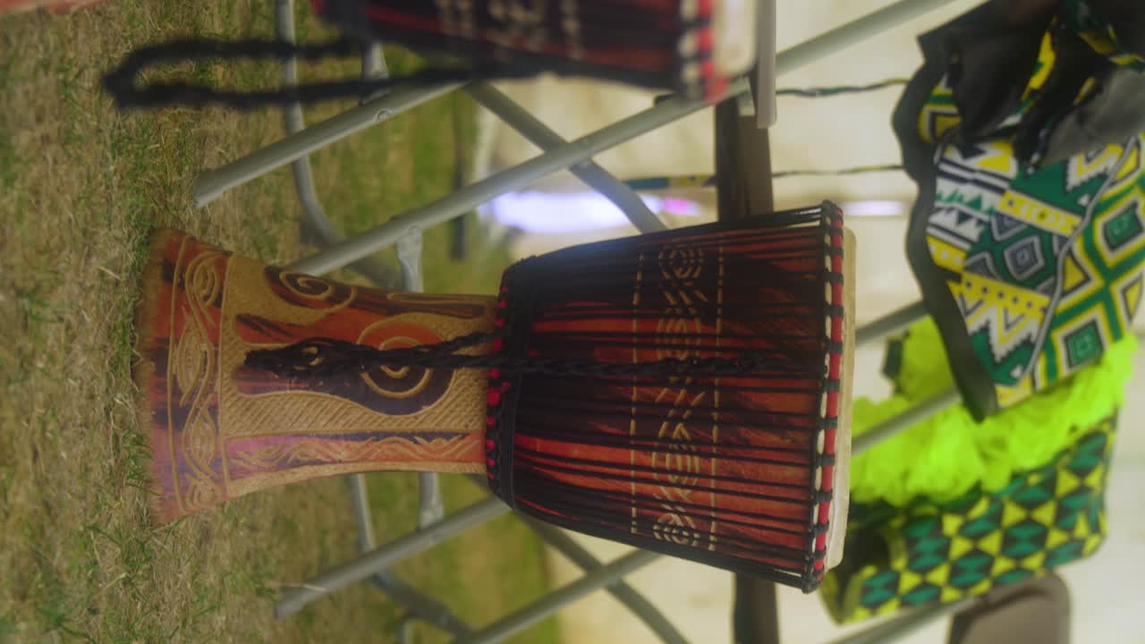 tambores africanos djembe colocados sobre un césped después de que una clase de música con estudiantes en una carpa lo dejó allí hermosos colores verdes de la tribu encubre el video vertical del festival de música de verano