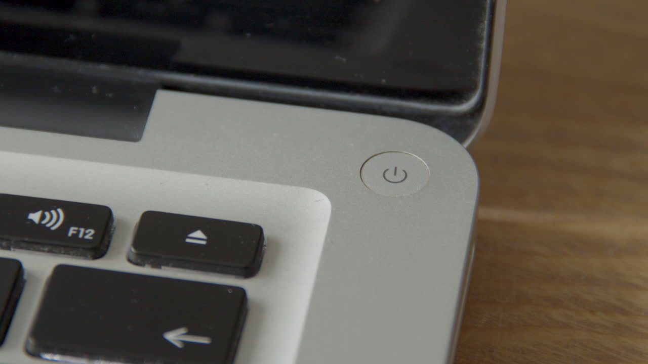 dedo presionando el botón de encendido y apagado en la computadora portátil varias veces