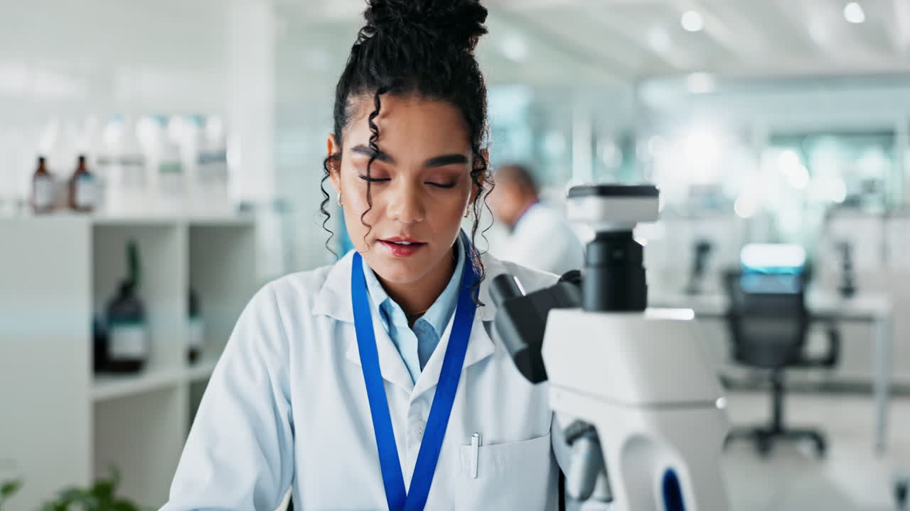 Scientist working in laboratory with microscope