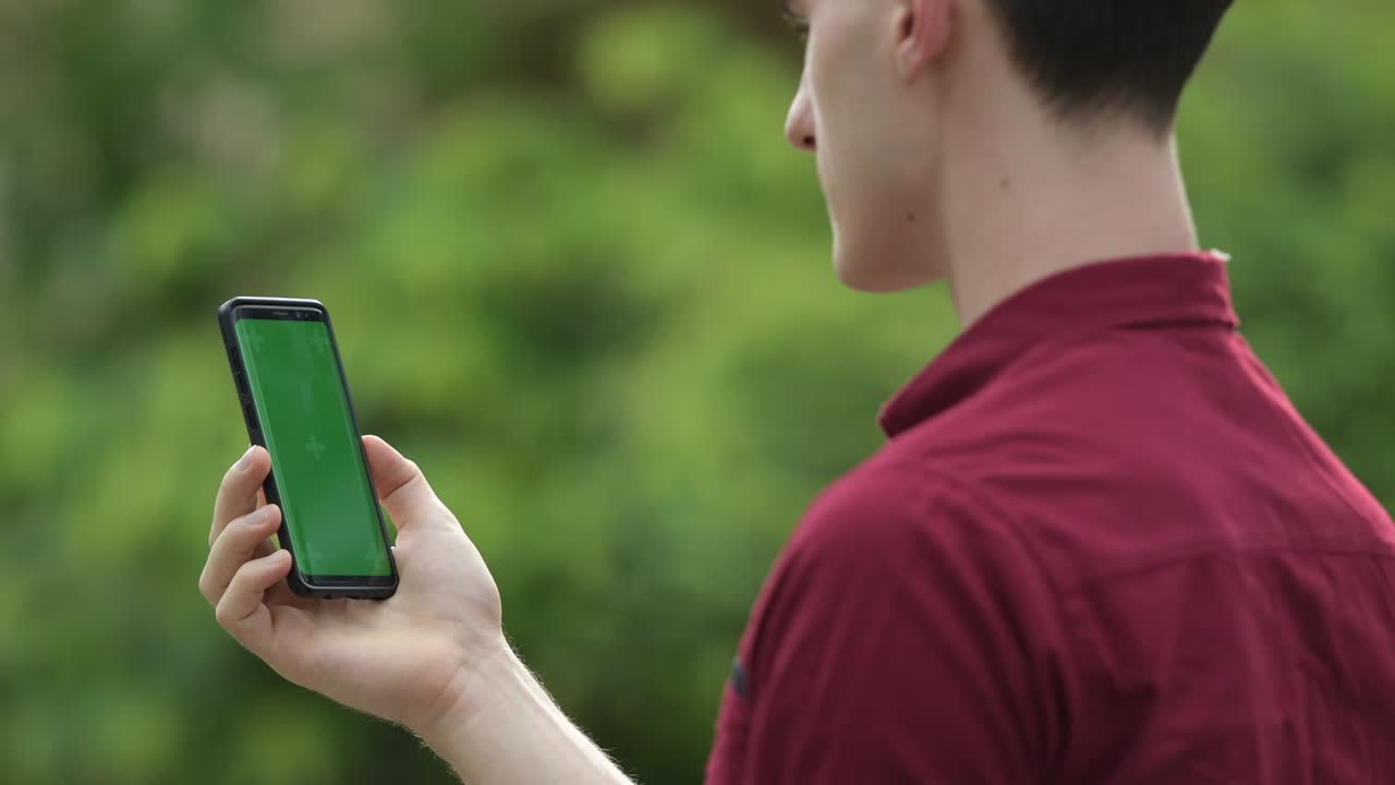 야외 거리에서 전화를 사용하는 젊은 잘생긴 사업가의 프로필 뷰