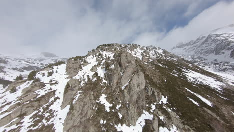 adelante aéreo sobre montaña rocosa nevada en día nublado, pirineos
