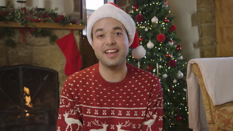 young man waving and talking to camera during christmas video call