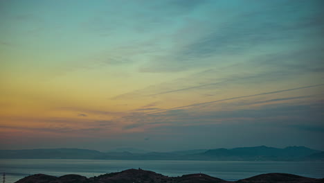 Impresionante-Puesta-De-Sol-Sobre-Un-Paisaje-Marino-Brumoso-Y-Un-Horizonte-Montañoso