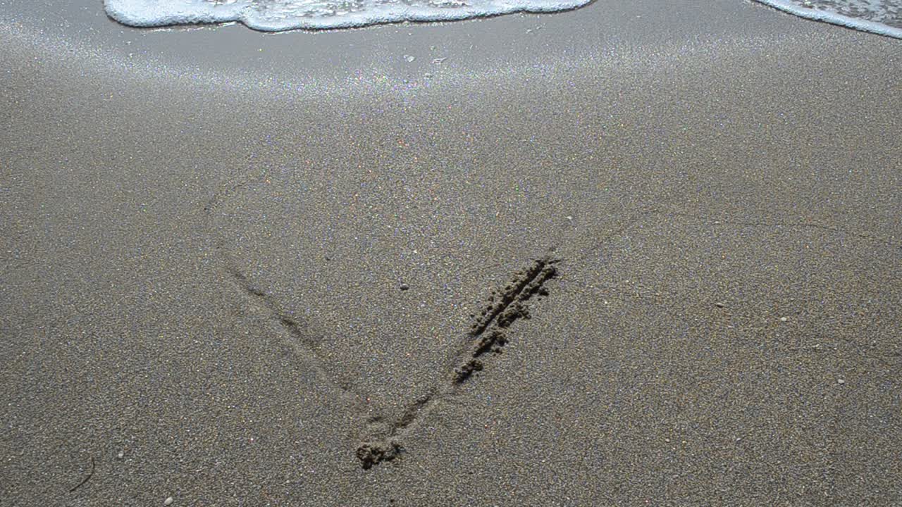 Ombak menyapu hati di pasir. Konsep cinta dan patah hati. Pemotretan di pantai