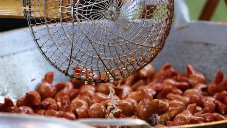 sausages frying in a large pan, bangkok street food