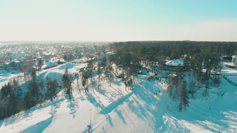 snowy-mountain-with-modern-ski-resort-and-track-aerial-view