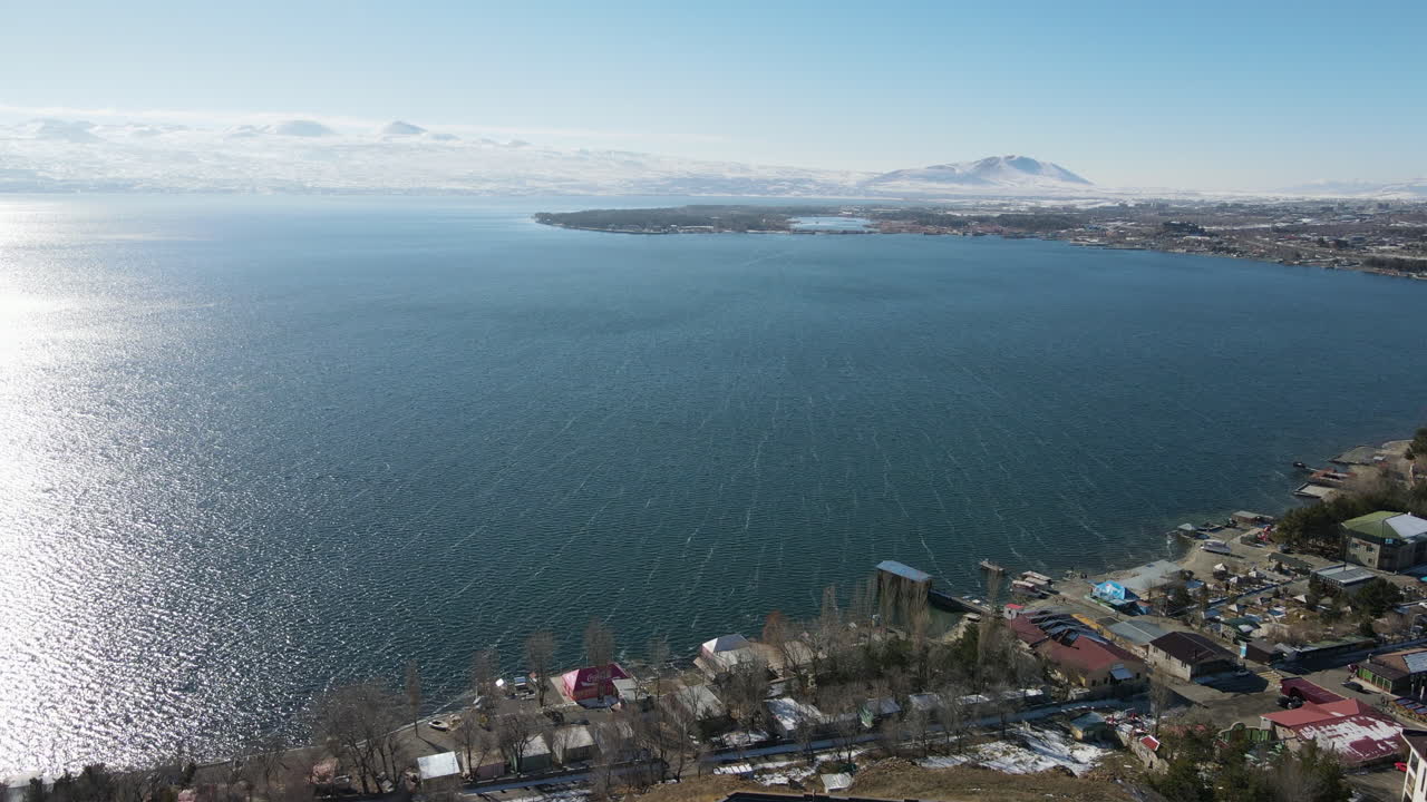 воздушный вид на озерный город с заснеженными горами