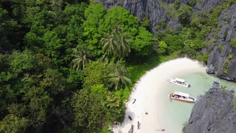 Aerial-view-above-the-Hidden-Beach,-Shallow-tropical-lagoon-surrounded-by-giant-karst-rock-mountains