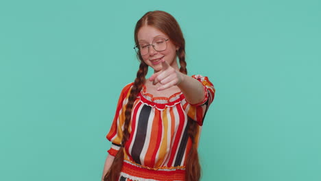 niña pelirroja señalando a la cámara y mirando con expresión alegre juguetona, haciendo una elección, hey usted