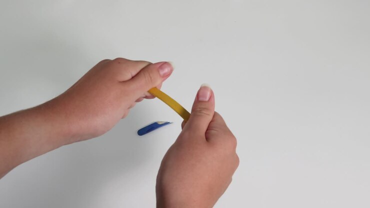 Two hands snapping a pencil into two pieces