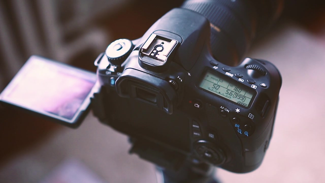 Una fotocamera DSLR montata su un treppiede fotografico.
