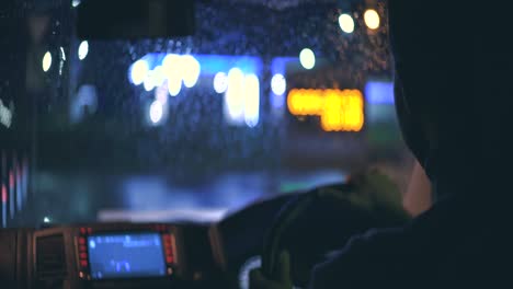 남자는 밤의 도시 고속도로에서 기계를 운전합니다.