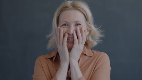 smiling woman with hands on face
