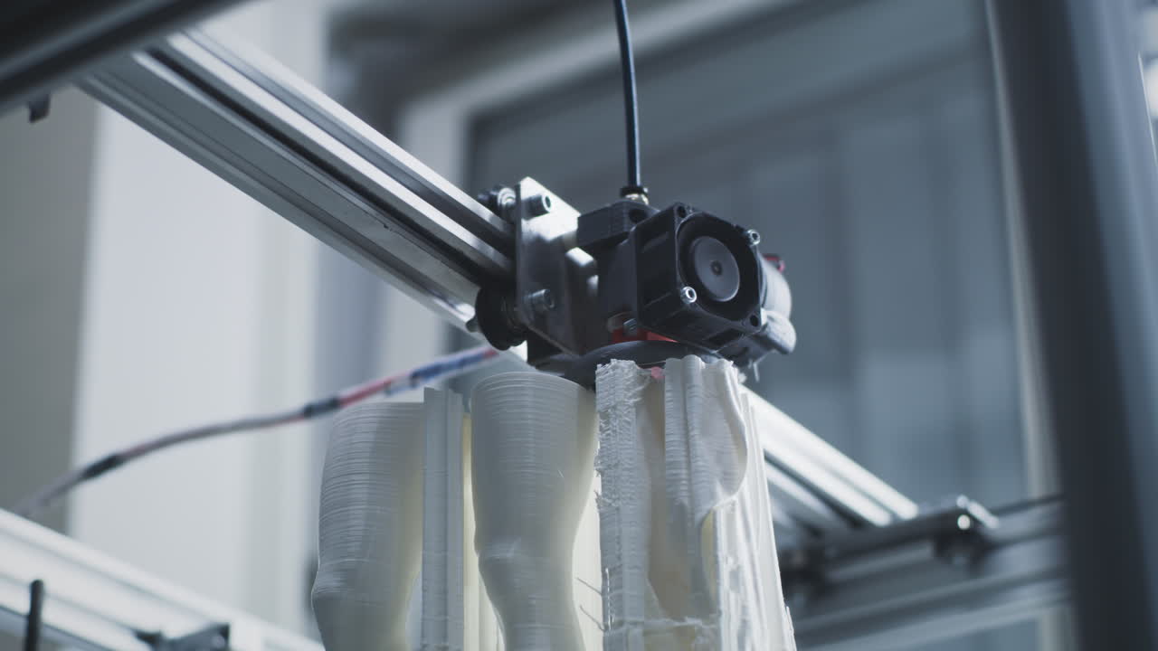 A 3D printer extruding white filament to create objects