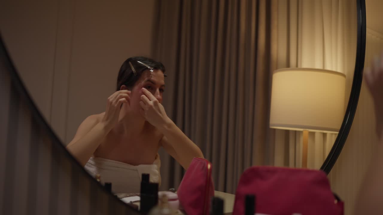Woman Applying Makeup in Mirror