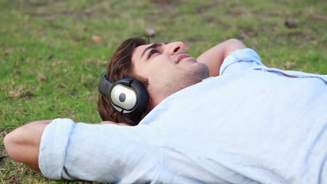 a man lies down while listening to music on his headphones