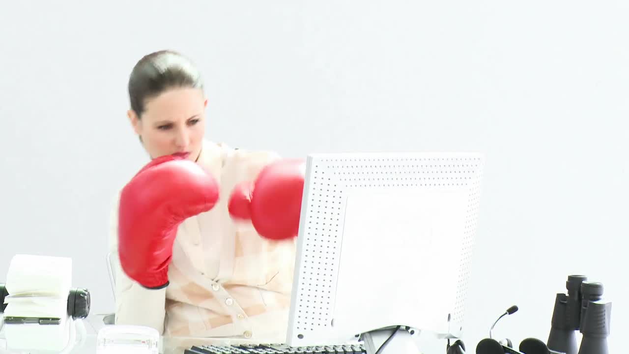 Confident businesswoman wearing boxing gloves