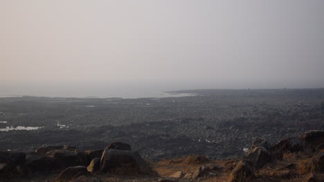 a young indian athlete jogging and stopped on mountain cliff near a ocean and enjoying view and weather after getting tired, video background in prores 422 hq
