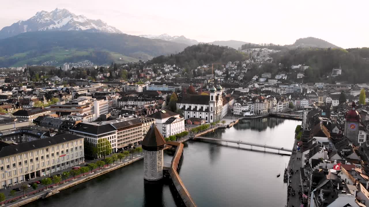 vista aérea de lucerna, suiza, con una vista del monte pilatus en el fondo mientras se mueve sobre el puente kapellbrücke hacia la iglesia jesuita