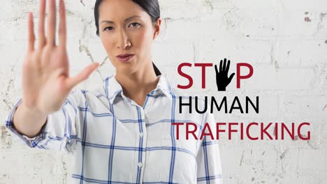 animation of stop human trafficking text over biracial woman with stop gesture