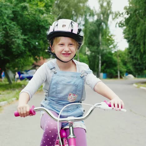Ein-Blondes-Mädchen-Mit-Helm,-Das-Auf-Der-Straße-Fahrrad-Fährt