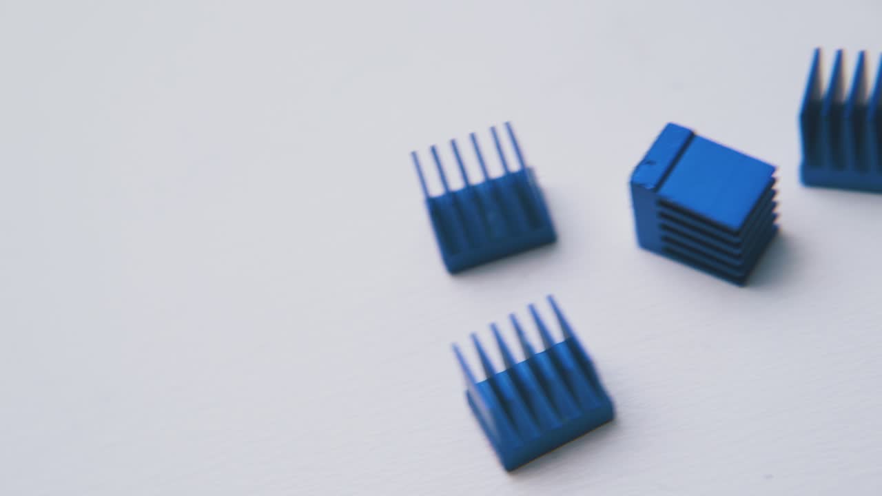 pequeños disipadores de calor azules para chips se encuentran en una superficie blanca limpia