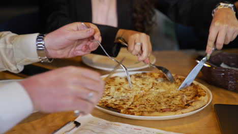 eating pizza during lunch break. colleagues cutting pizza in the company cafeteria. lunchtime at work.
