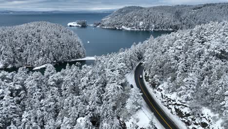 vista aérea ascendente de la bahía bowman y la isla fidalgo cubierta de nieve fresca