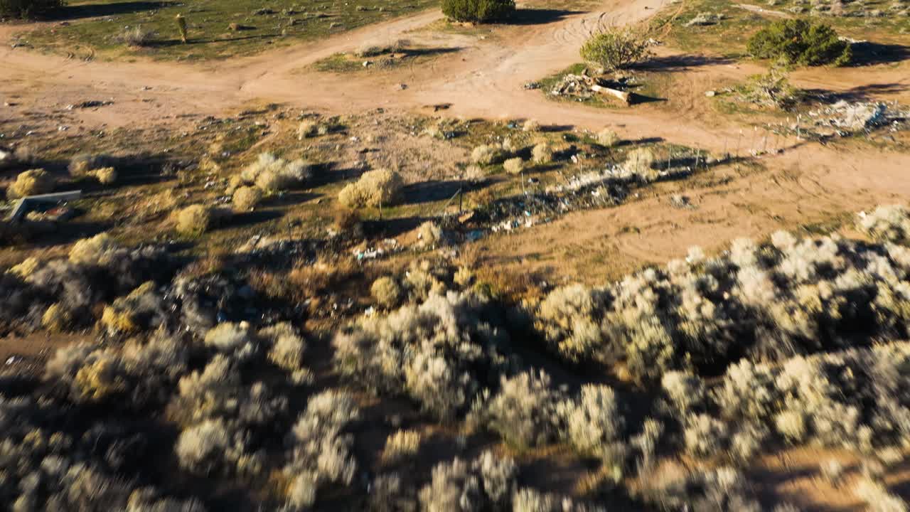 조슈아 나무 건물과 눈 덮인 산을 배경으로 보여주는 이른 아침에 높은 사막 헤스페리아 캘리포니아 빅터빌의 공중을 천천히 돌리십시오.