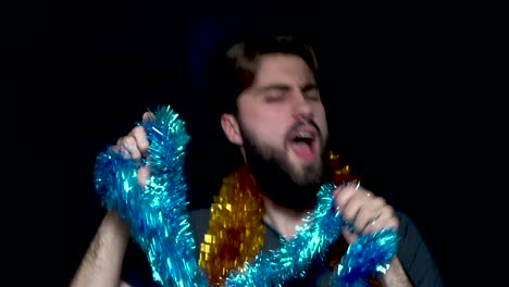 man excitedly playing with christmas tinsel