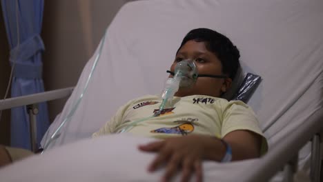 Cute-little-boy-with-oxygen-mask-on-her-face-on-bed-in-the-hospital