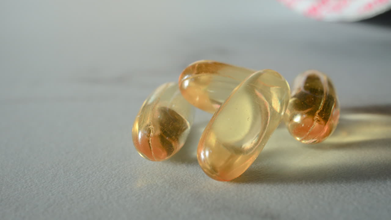 Close up of fish oil supplements scattered on a white table