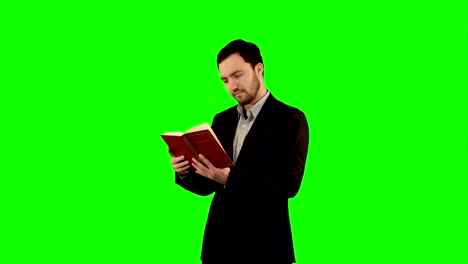 university student with book on laptop on a green screen, chroma key