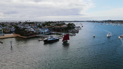 Aerial-rising-shot-of-boats-at-the-Newport-Beach,-in-partly-sunny-Los-Angeles,-USA