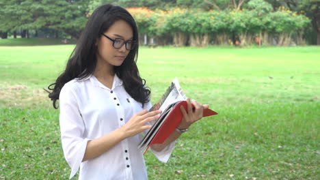 Mujer-Estudiante-Leyendo-Un-Libro-En-El-Parque-Universitario