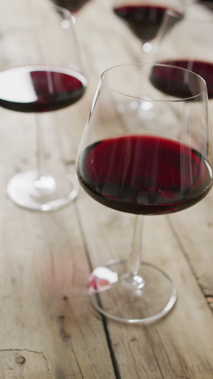 Video verticale di vino rosso nei bicchieri su un tavolo di legno
